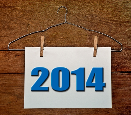 Hanger of white paper 2014 on wood background