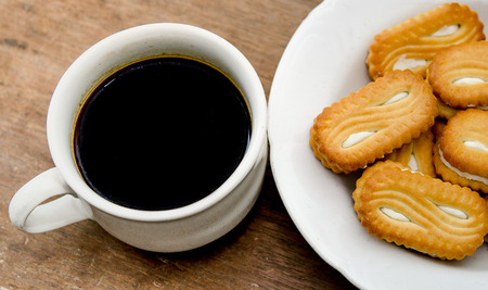 Black coffee with cookie on wood tableの写真素材