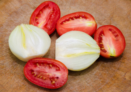 Chop tomato and onion on chopping woodの写真素材
