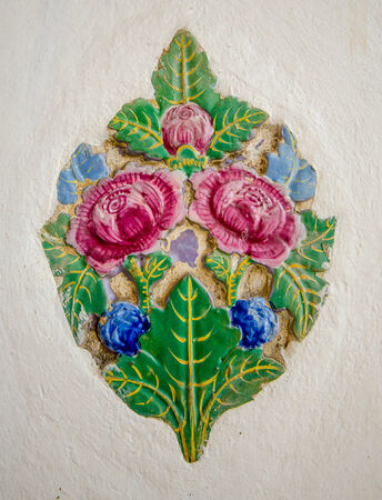 Old ceramic tile of rose on wallの写真素材
