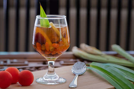 Natural healthy herbal drink in a clear glass, with fresh vegetables and fruits ingredients