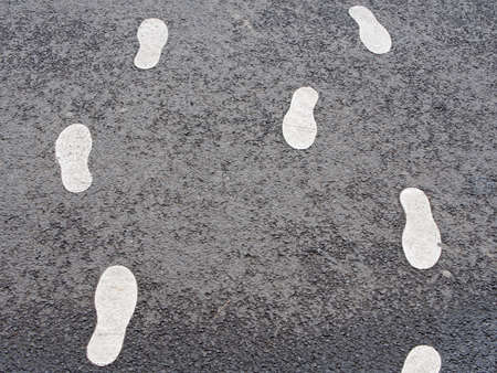 Diversity Concept: Footsteps On Wet Asphalt Leading In Opposite Directionsの写真素材