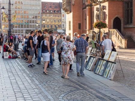 WROCLAW, POLAND - AUGUST 15, 2017: Painter Selling Pictures At Rynek Market Square In Wroclaw, Tourists Looking At The Picturesのeditorial素材