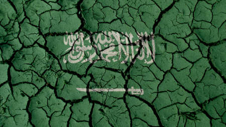 Political Crisis Or Environmental Concept: Mud Cracks With Saudi Arabia Flagの写真素材