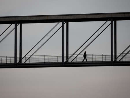 The Silhouette of A Woman Walking On A Bridgeの写真素材