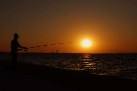 fishing while sun goes downの写真素材