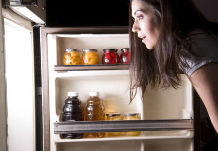 A woman raids the refrigerator late at nightの写真素材