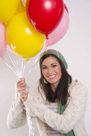 Beautiful Brunette hold a bunch of colorful balloonsの写真素材