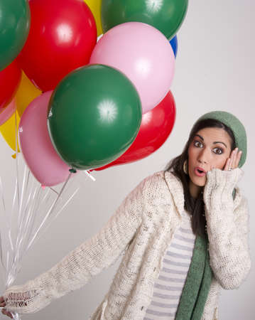 Beautiful Brunette hold a bunch of colorful balloonsの写真素材