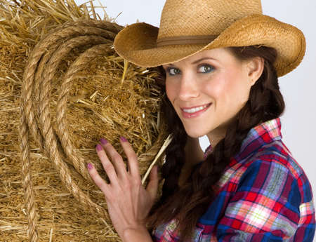 Portrait of a Western Woman by a bale of hayの写真素材