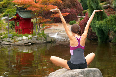 A woman practices Yoga in a beautiful placeの写真素材
