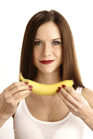 A beautiful brunette shows you her fruit snackの写真素材