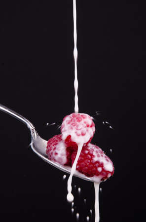A few pieces of fruit in a spoon milk droppingの写真素材
