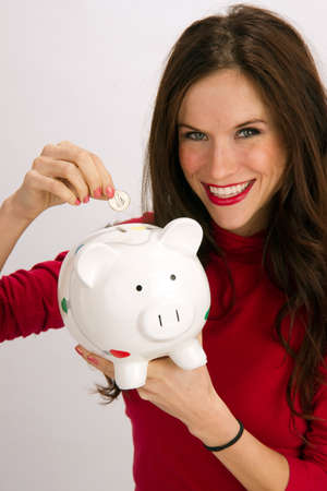 An Active and Attractive places coins in the Piggy Bankの写真素材