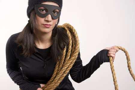 A thief lurks around the house after using a rope to gain entry upstairsの写真素材