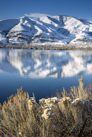 Columbia River Flows After Fresh Snow beneath Mountain Peaks and Homesteadsの写真素材