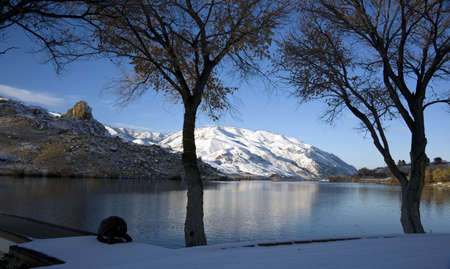 Winter Snow on the Peaceful Columbia River under the trees looking at a rock butteの写真素材