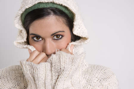 Sensual Attractive Woman Covering Half Her Face with Hands and Sweaterの写真素材