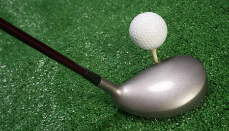 A golf club prepares to drive the ballの写真素材