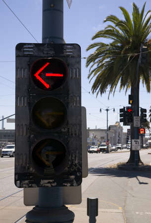 3-Way Left Turn Signal Street Traffic Controller Device Downtown City Corner Currently Showing Red Arrowの写真素材
