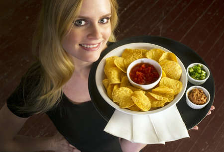 A Young Attractive Female Server Brings Appetizer Food Trayの写真素材