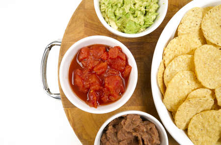 Food Appetizers Chips and Salsa Refried Beans Guacamole on Wood Cutting Boardの写真素材