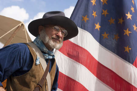 Steilacoom, Washington, USA - May 1, 2010: A scout for the Army Civil War Re-enactors stands by flag in camp at re-enactment in the Pacific Northwest.のeditorial素材