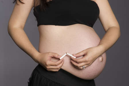 A health minded woman breaks last cigarette in halfの写真素材