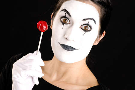 Woman made up in white face holds red sweet lollipopの写真素材