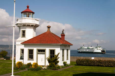 A ferry leaves the dock behind a coastal nautical beacon on puget soundの写真素材