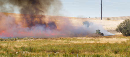 Farmers do a controlled burn before plowing after harvestの写真素材
