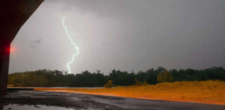 Lightning strikes outside the cover of a South Texas highway overpassの写真素材