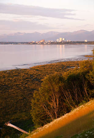 A pink sunset reflects light on the buildings and waterの写真素材