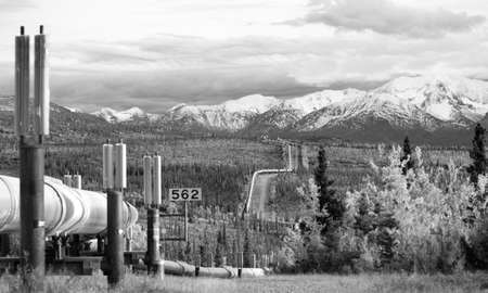 The large diameter pipe that cuts across the mountainous Alaska Landscapeの写真素材