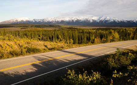 The highway cuts past the last tundra before turning into the mountainsの写真素材