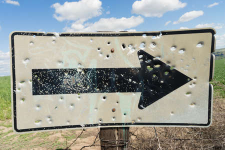 Someone or several people have damaged a road sign by shooting itの写真素材