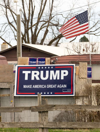 An American Flag flies over a political support sign for the Trump presidency