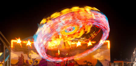 Lights going around on a carnival ride create red streaksの写真素材