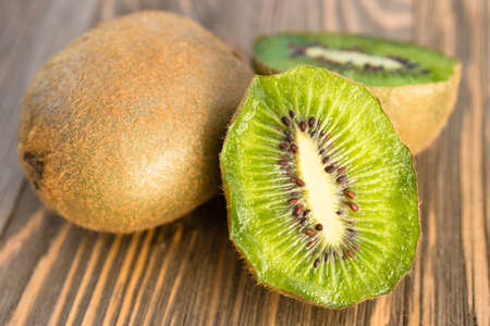 Two Kiwi Fruits sit on the cutting board on cut in halfの写真素材