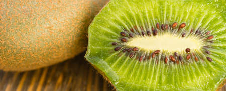 Two Kiwi Fruits sit on the cutting board on cut in halfの写真素材
