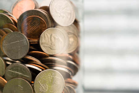 A selection of coins contained in a glass jarの写真素材