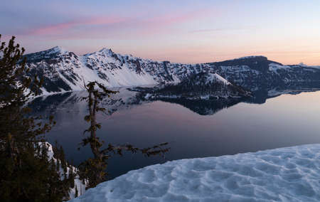 Sunrise generates pink hues over Crater Lake National Parkの写真素材