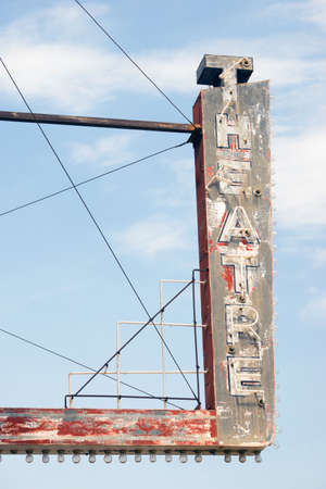 Vertical composition metal neon theatre sign against blue skyの写真素材