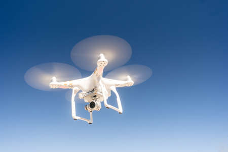 A Quadcopter hovering against a dark blue sky in a long panoramic compositionの写真素材