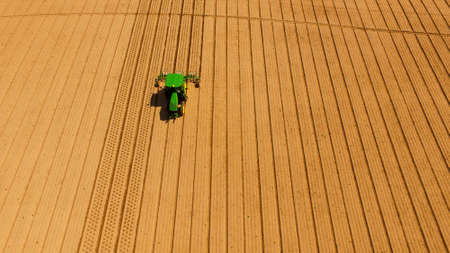 Farm hands work the aerators on a smooth well cultivated field