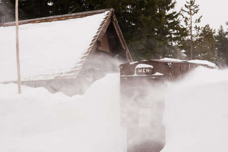 The walkway and entry to this Men's Room is covered in ice and snow as the wind blows