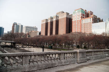 Buds are just starting on the trees that line the park below apartment buildings and offices in Chicagoのeditorial素材
