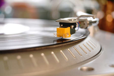 An analog record turns around on top of an old school phonograph playerの写真素材
