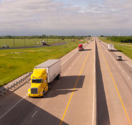 A bright and colorful 18 Wheeler motors down the highway with trailer attachedの写真素材