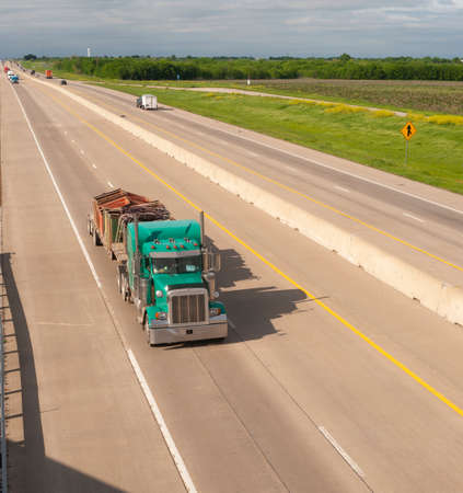 A bright and colorful 18 Wheeler motors down the highway with trailer attachedのeditorial素材
